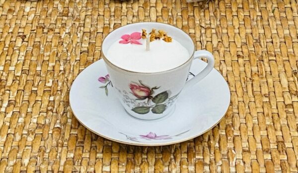 Une bougie dans une jolie tasse fleurie vintage